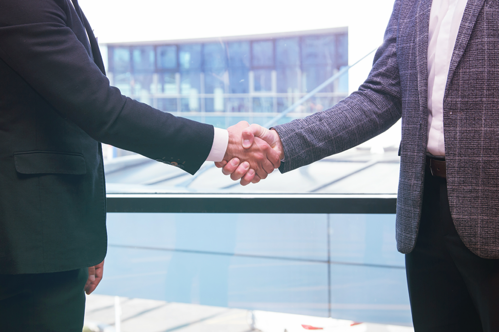 Two businessmen shake hands in successful conclusion of a business transaction between two logistics companies