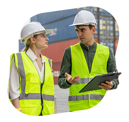 Three logistics operators working together in a container yard looking at a tablet
