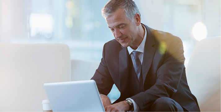 Businessman working on a laptop, addressing the complexities of the supply chain through intelligence, strategic vision, and integration.