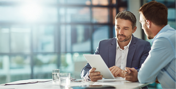 Two business professionals reviewing information on a tablet, collaborating on business decisions using the Grydd platform.