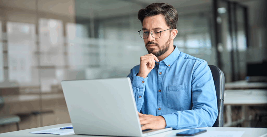A supply chain business owner using a laptop to review their bank reconciliations and automate their audit records using Grydd Expentra