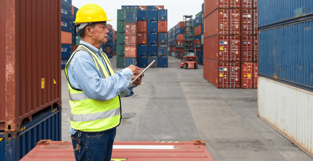 Medium shot of a logistics agent observing and inspecting a container in a container yard.