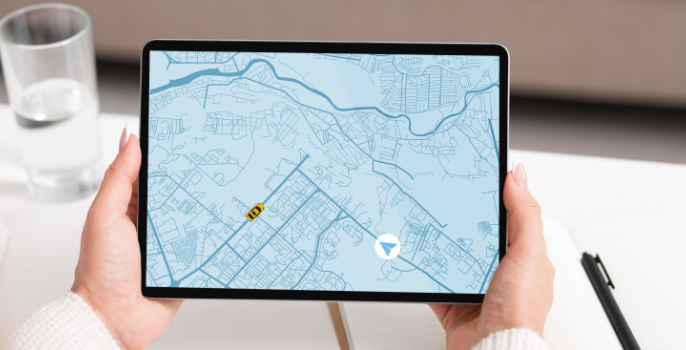 The hands of a supply chain business professional hold a tablet, demonstrating how they leverage data to predict the most efficient and cost-effective routes for their shipments, taking into account factors such as traffic, weather conditions, fuel costs, and delivery deadlines, all thanks to Grydd Sphere.