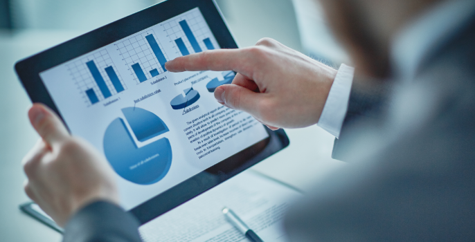 A supply chain manager using a tablet and Grydd Compass for continuous monitoring, measurement, and analysis of key performance indicators, and to evaluate the effectiveness, efficiency, and success of their supply chain operations.
