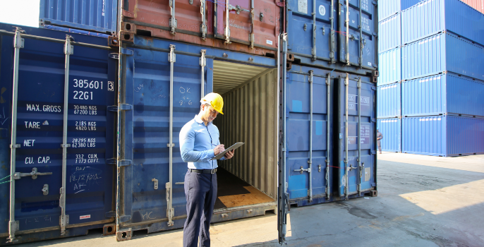 A logistics agent in a container yard uses a tablet with Grydd Sphere and its advanced AI algorithms to analyze the dimensions of the cargo, weight distribution, package arrangement, and container capacity, in order to create the most space-efficient loading plans.
